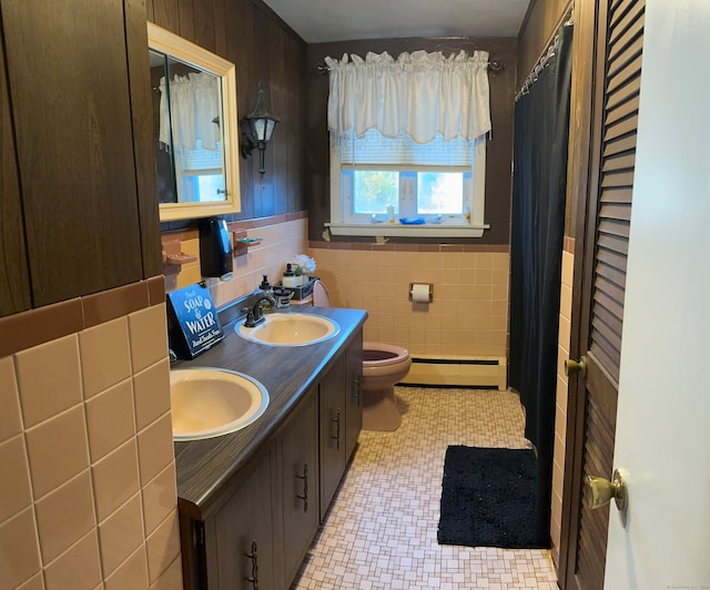 bathroom featuring tile walls, a baseboard radiator, vanity, and toilet