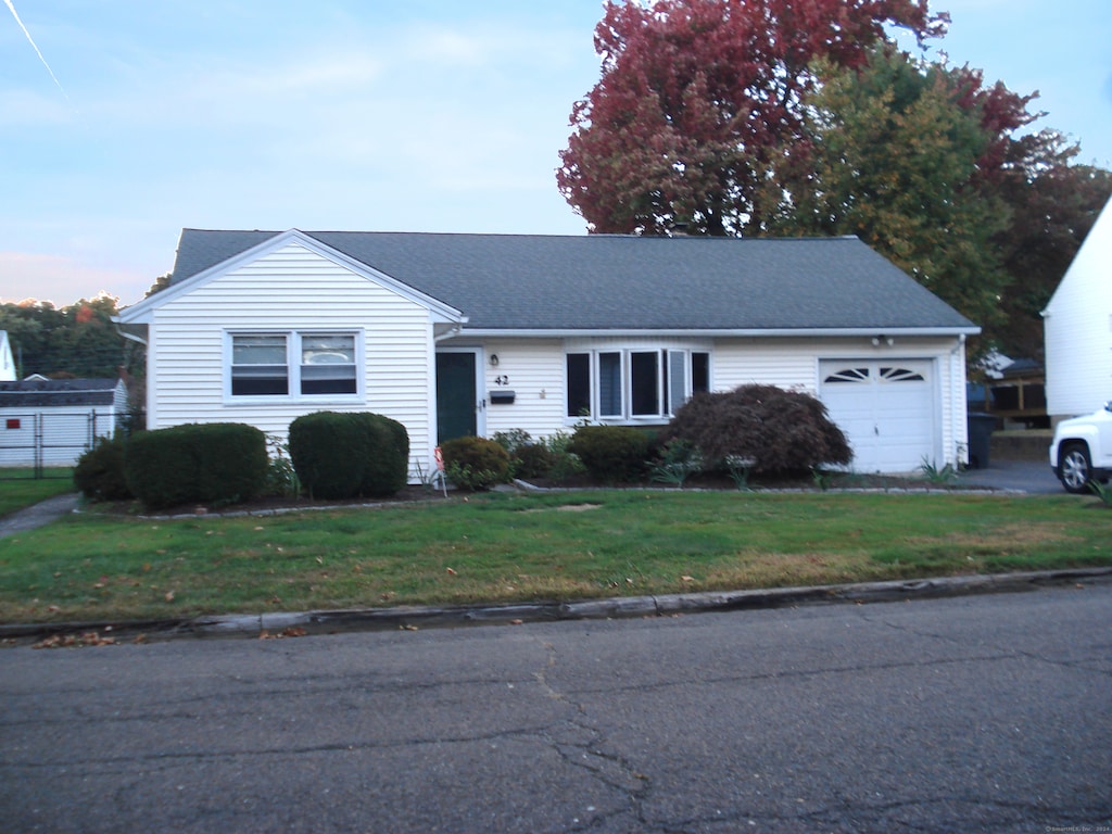 view of front of property with a garage and a front yard