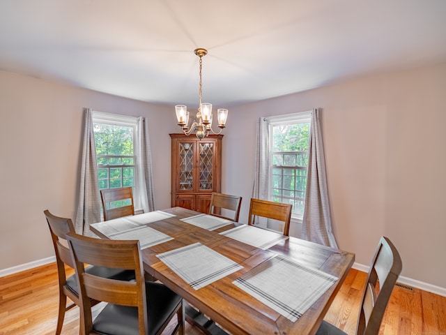 dining space featuring plenty of natural light, a chandelier, and light hardwood / wood-style flooring