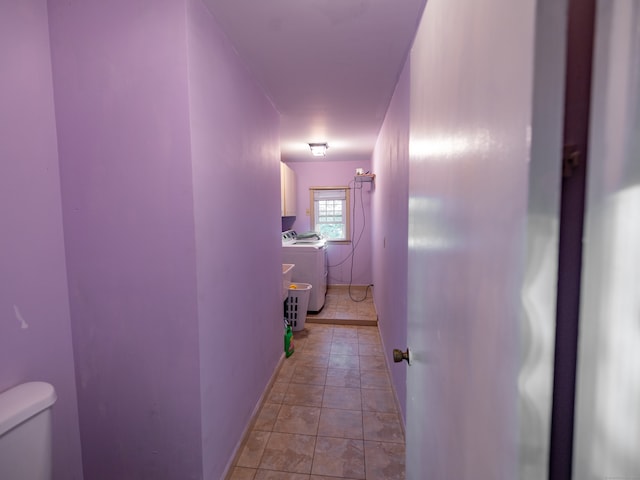 hall with washing machine and clothes dryer and light tile patterned floors