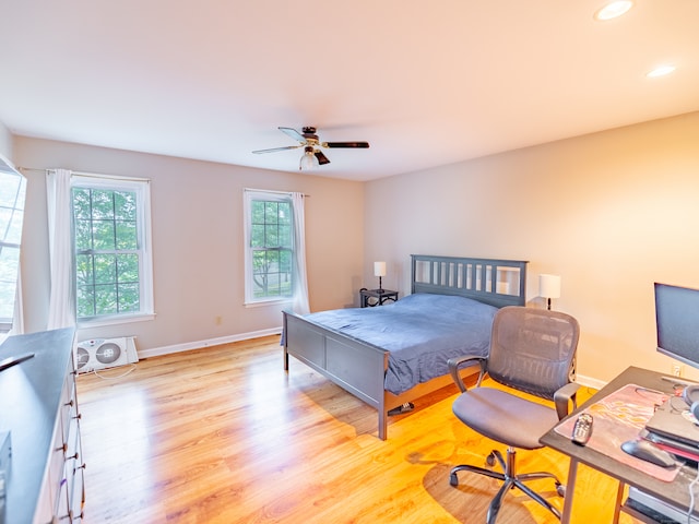 bedroom featuring light wood-type flooring, multiple windows, and ceiling fan