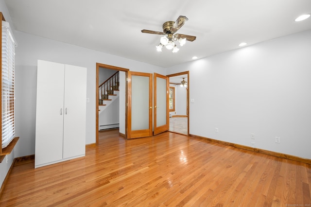 unfurnished bedroom with ceiling fan, light hardwood / wood-style floors, and baseboard heating