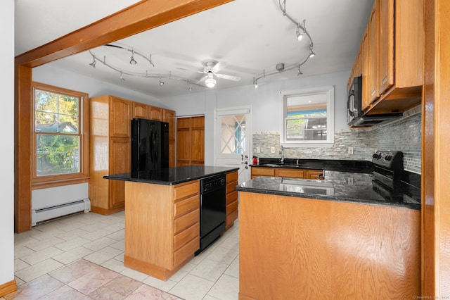 kitchen featuring sink, backsplash, a baseboard heating unit, black appliances, and a center island