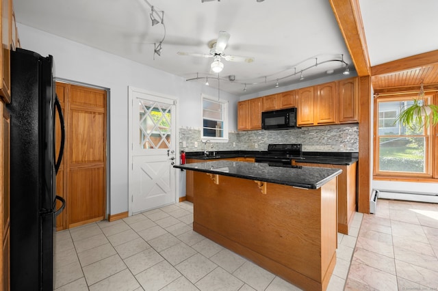 kitchen featuring a kitchen island, dark stone countertops, sink, decorative backsplash, and black appliances