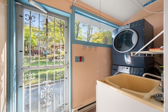 laundry area featuring sink, stacked washing maching and dryer, and baseboard heating