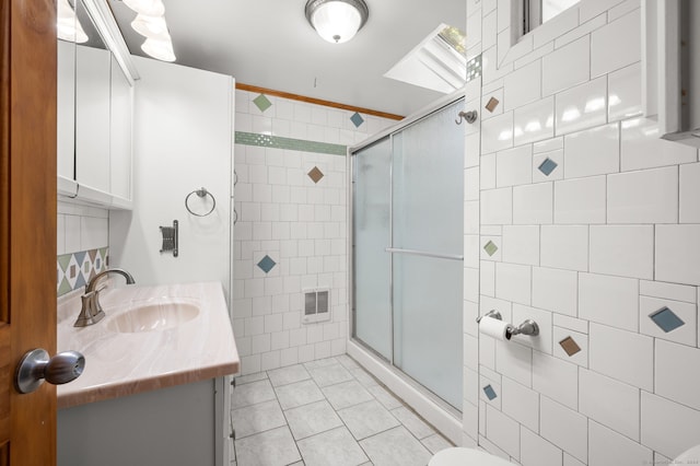 bathroom with an enclosed shower, toilet, tile walls, and vanity