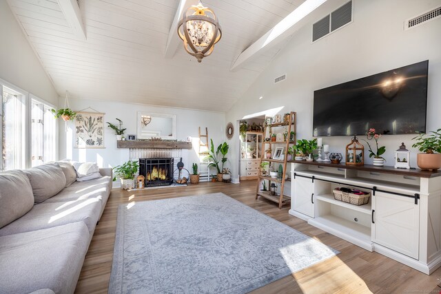 living room featuring a fireplace, wood-type flooring, high vaulted ceiling, and beam ceiling