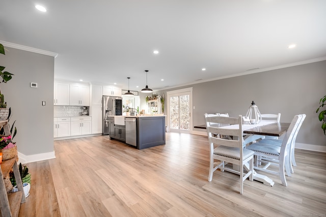 dining area with light hardwood / wood-style flooring and ornamental molding