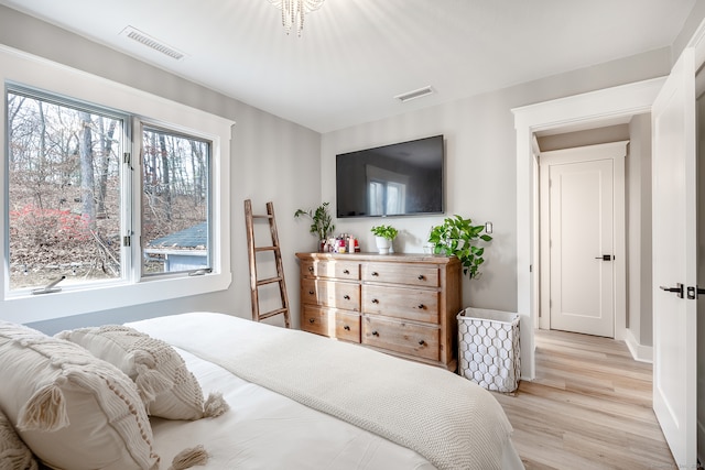 bedroom featuring light hardwood / wood-style floors and an inviting chandelier