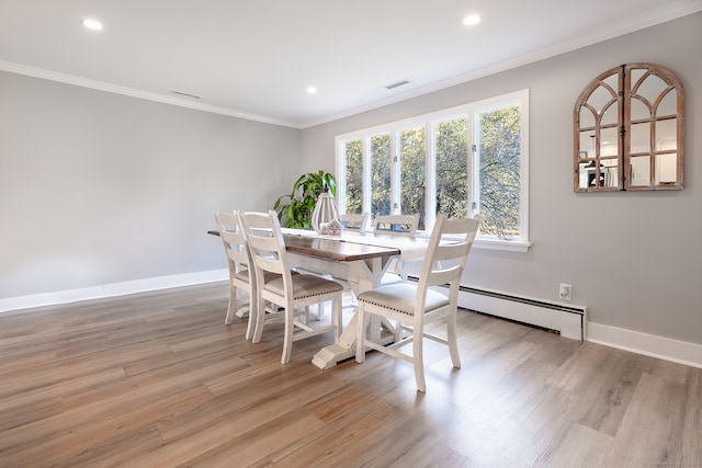 dining room with ornamental molding, light hardwood / wood-style floors, and a baseboard heating unit