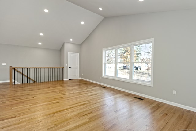 empty room featuring light hardwood / wood-style floors and high vaulted ceiling