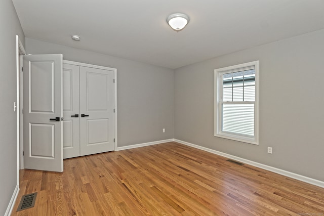 unfurnished bedroom with a closet and light hardwood / wood-style floors