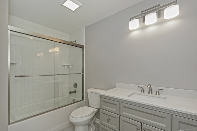 full bathroom featuring toilet, combined bath / shower with glass door, and vanity