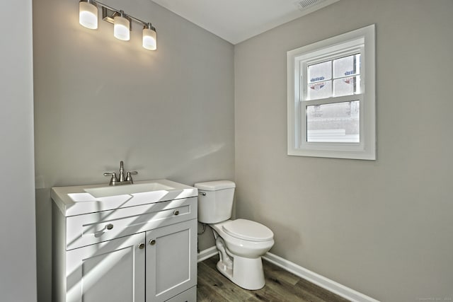 bathroom with hardwood / wood-style floors, vanity, and toilet