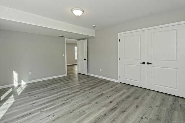 unfurnished bedroom featuring light wood-type flooring and a closet