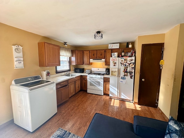 kitchen with dark hardwood / wood-style floors, white appliances, sink, and washer / clothes dryer