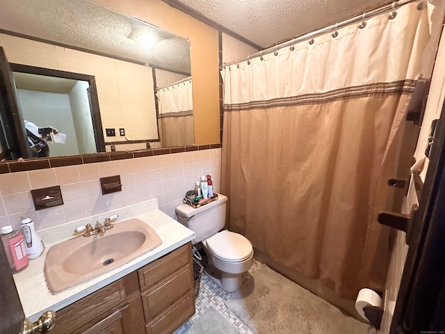 bathroom featuring tile walls, vanity, a textured ceiling, and toilet