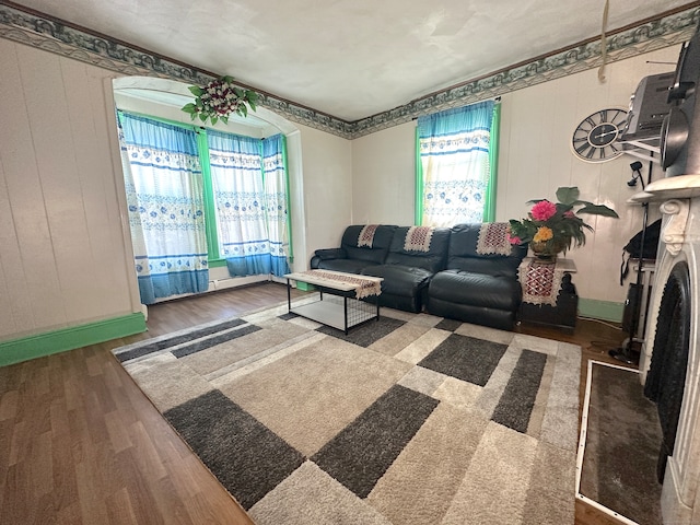 living room featuring wooden walls, a wealth of natural light, and dark hardwood / wood-style flooring