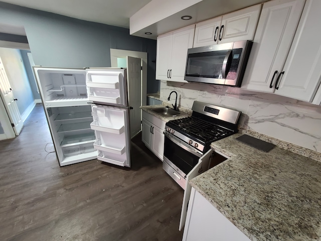 kitchen with white cabinets, appliances with stainless steel finishes, dark wood-type flooring, and sink