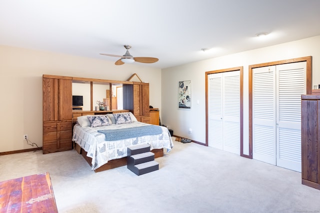 carpeted bedroom featuring two closets and ceiling fan