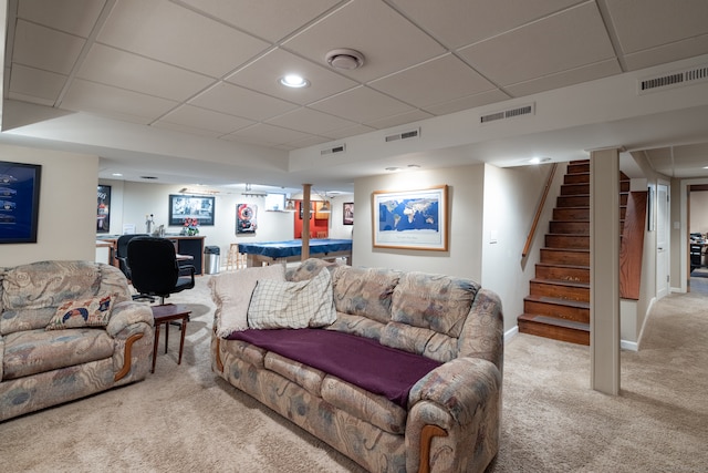 carpeted living room with a drop ceiling