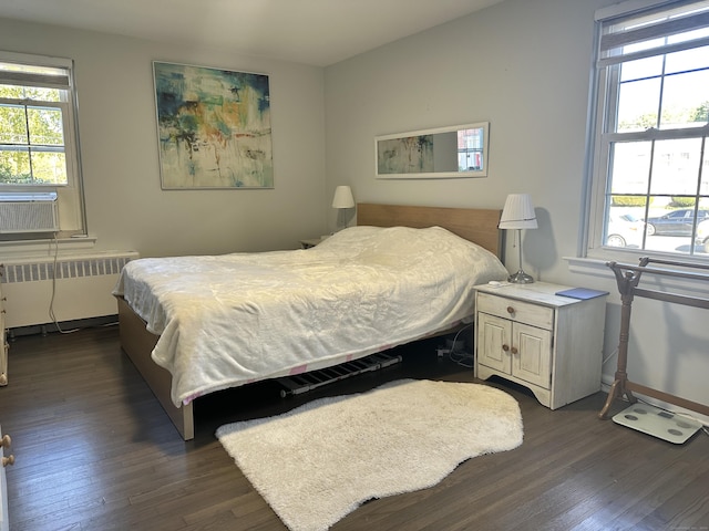 bedroom featuring dark hardwood / wood-style floors, radiator, and cooling unit