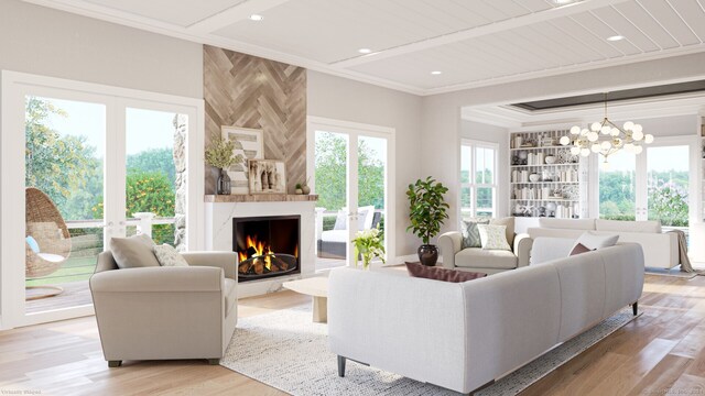 living room featuring french doors, crown molding, a premium fireplace, a notable chandelier, and light hardwood / wood-style floors