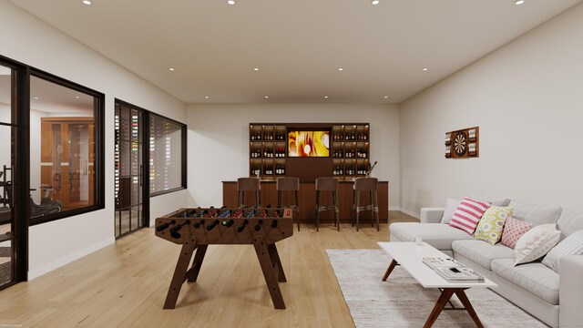 game room with bar area and light wood-type flooring