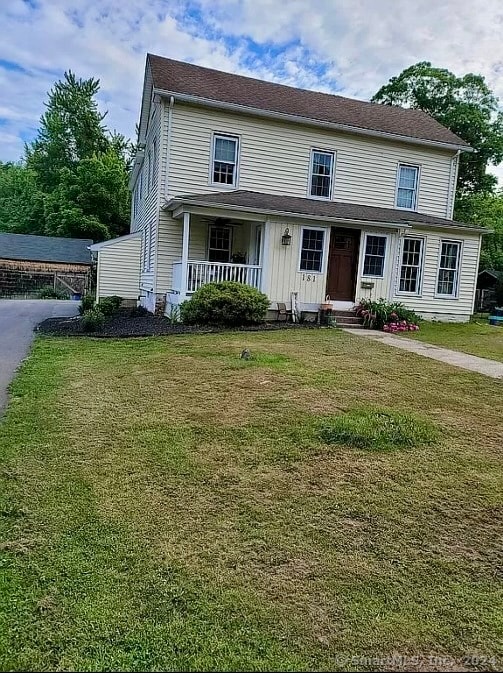 view of front of home with a porch and a front yard