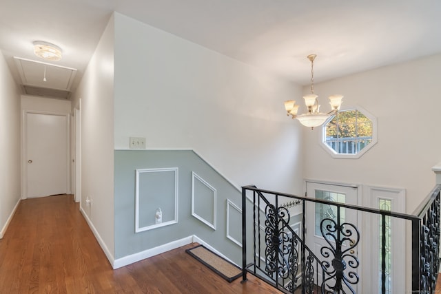 hallway with a chandelier and dark wood-type flooring