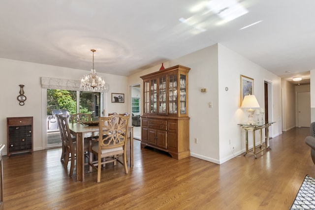 dining area featuring dark hardwood / wood-style floors and a chandelier