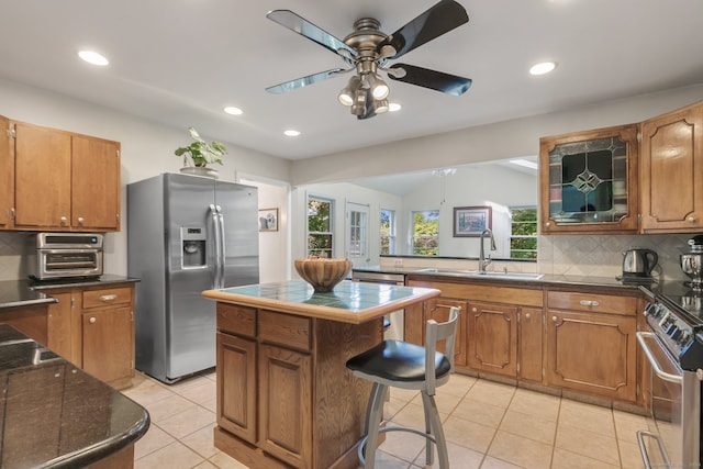 kitchen featuring appliances with stainless steel finishes, a center island, decorative backsplash, and a healthy amount of sunlight