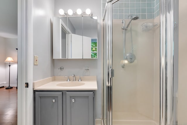 bathroom featuring hardwood / wood-style floors, vanity, a baseboard radiator, and an enclosed shower