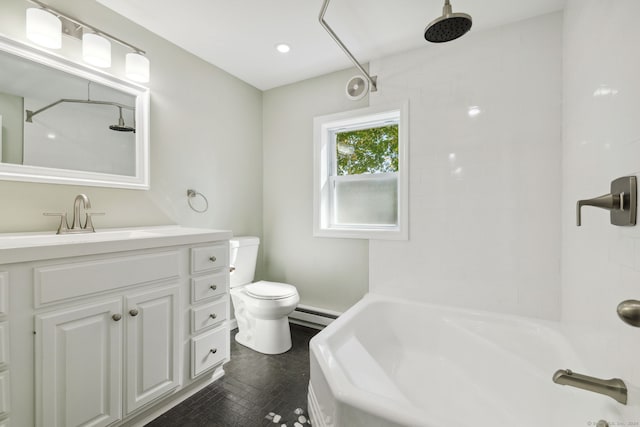 full bathroom with tiled shower / bath, vanity, baseboard heating, tile patterned floors, and toilet