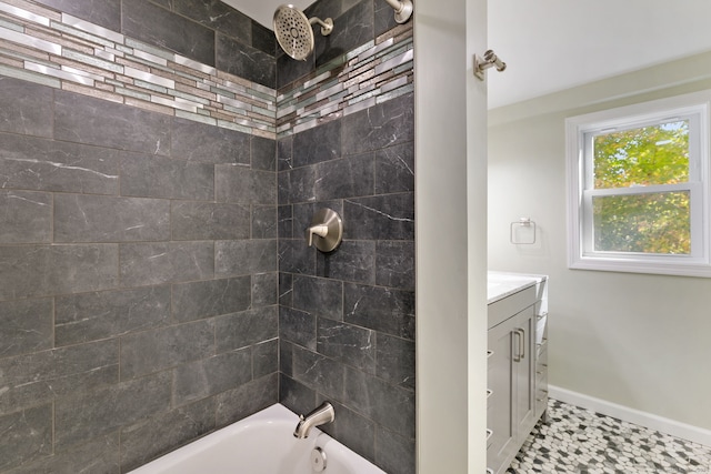 bathroom with tile patterned flooring, tiled shower / bath, and vanity