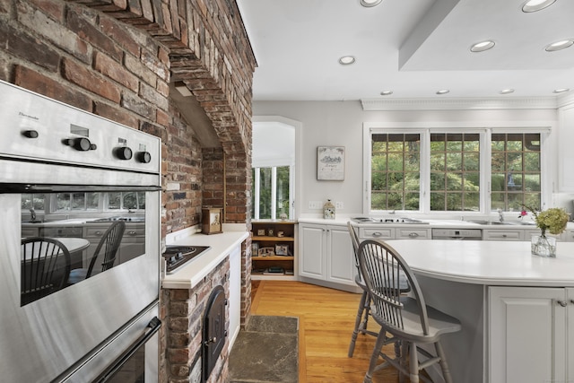 6 Tantummaheag Rd, Old Lyme, CT 06371 - kitchen featuring stainless steel oven, light wood-style flooring, light countertops, white cabinetry, and recessed lighting