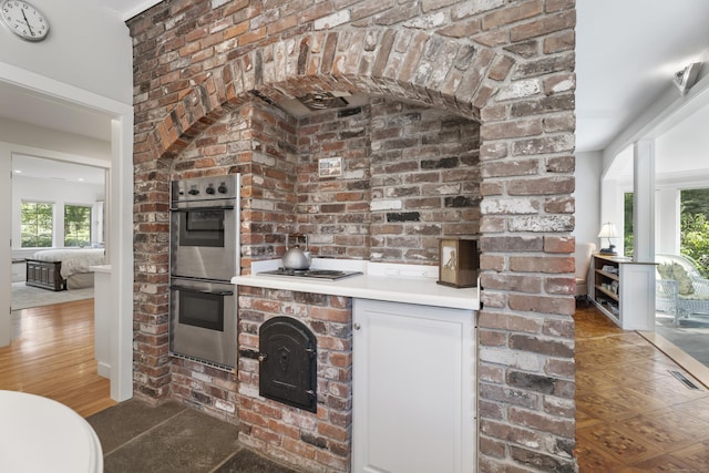 6 Tantummaheag Rd, Old Lyme, CT 06371 - kitchen featuring double oven, cooktop, light countertops, white cabinets, and wood finished floors