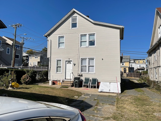 rear view of property featuring a yard