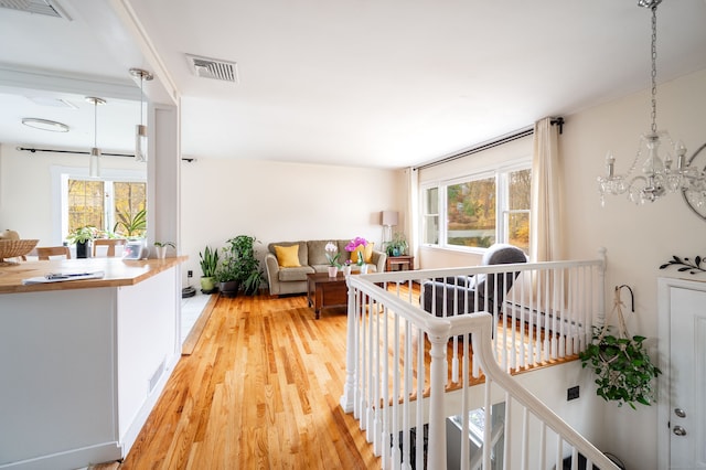 living room featuring light hardwood / wood-style flooring, plenty of natural light, and an inviting chandelier