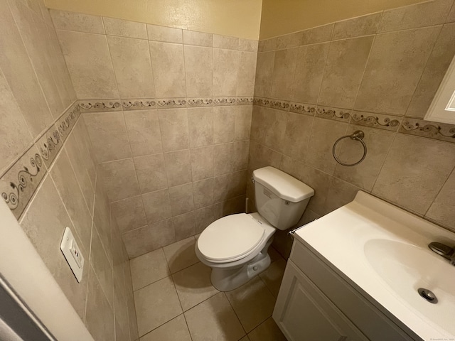 bathroom featuring tile walls, vanity, toilet, and tile patterned flooring