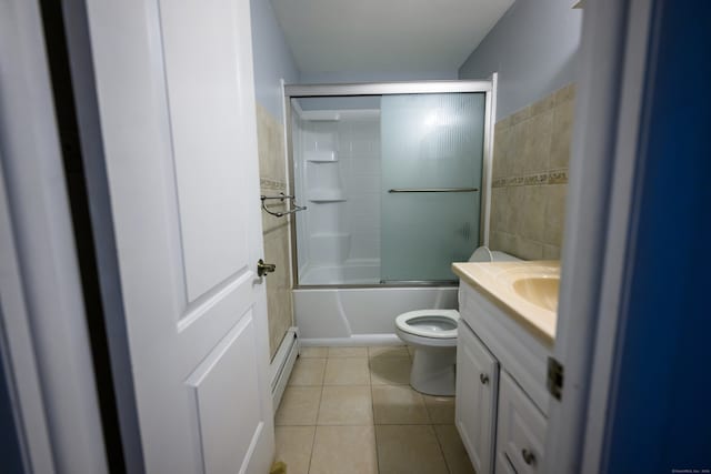 full bathroom with toilet, tile patterned floors, tile walls, bath / shower combo with glass door, and vanity