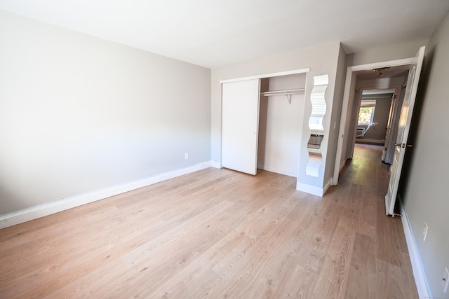 unfurnished bedroom featuring a closet and light wood-type flooring