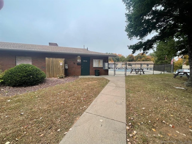 view of front of home with a front lawn and a swimming pool