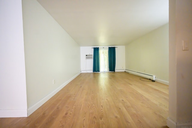 interior space featuring hardwood / wood-style flooring, a baseboard heating unit, and a wall unit AC