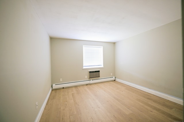 unfurnished room with baseboard heating, a wall mounted air conditioner, and light wood-type flooring