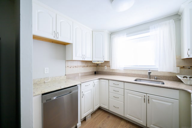 kitchen featuring decorative backsplash, white cabinets, stainless steel dishwasher, light hardwood / wood-style flooring, and sink