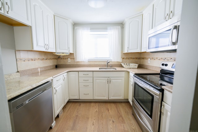 kitchen featuring white cabinetry, light hardwood / wood-style flooring, stainless steel appliances, and sink