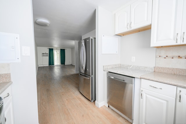 kitchen with appliances with stainless steel finishes, white cabinetry, and light hardwood / wood-style floors