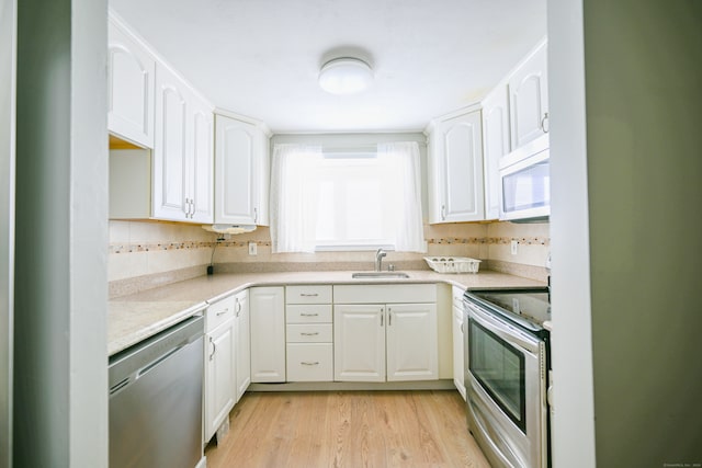 kitchen with white cabinetry, stainless steel appliances, and sink