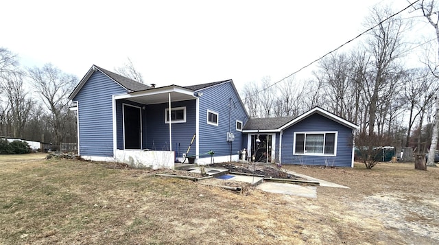 rear view of house featuring a yard